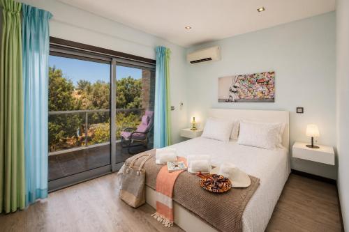 a bedroom with a bed and a large window at Villa Clara do Sol in Estói