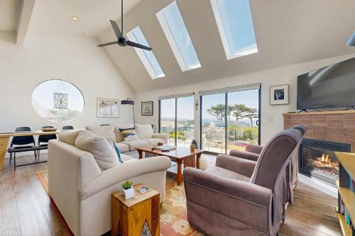 a living room with couches and a tv and a fireplace at Heron Escape in Bodega Bay