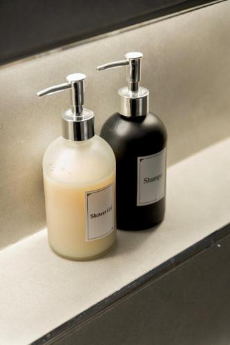 two bottles of soap sitting on a shelf at Groves Chalet in Rumays
