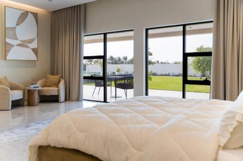 a bedroom with a large white bed and a table at Groves Chalet in Rumays