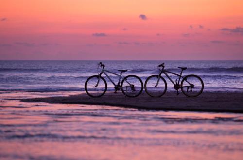 two bikes are parked on the beach near the water at U Paasha Seminyak Bali in Seminyak