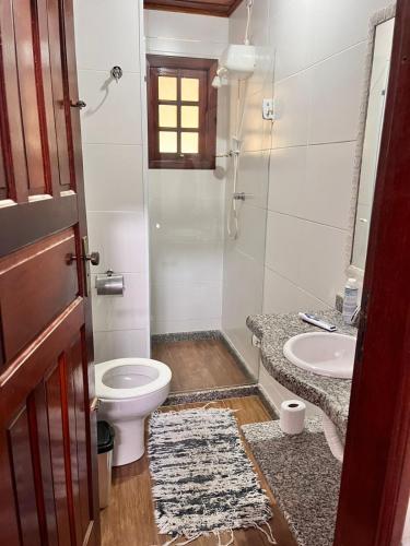 a bathroom with a toilet and a sink at Casa da Jabuticaba! in Itatiaia