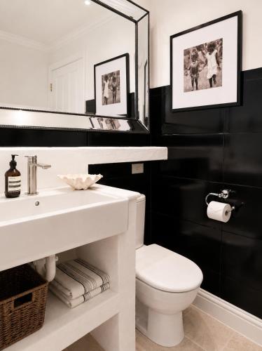 a bathroom with a white sink and a toilet at Avalon Beach Cottage- The Islander in Avalon