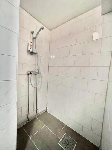 a shower in a white tiled bathroom at Joselia in Falkenberg