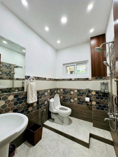 a bathroom with a toilet and a sink and a tub at The Yak Motel in Skardu