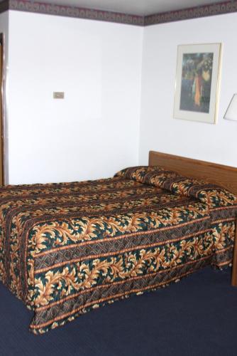a bed in a bedroom with a blanket on it at Viking Jr. Motel in Saint Peter