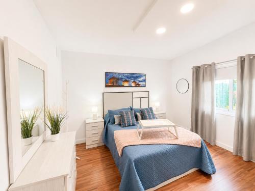a white bedroom with a bed and a window at Las casitas de Zamorano in La Esperanza