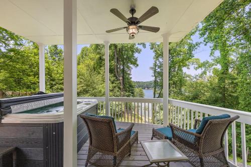 a porch with a hot tub and two chairs and a ceiling fan at Heron Hideaway in Wilkesboro