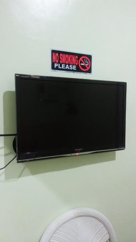 a flat screen tv with a no smoking sign on it at Dweller's Pensione in Iloilo City