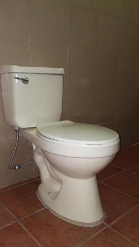 a bathroom with a white toilet in a room at Dweller's Pensione in Iloilo City