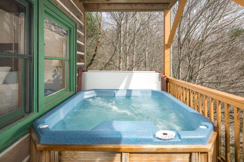 a jacuzzi tub on the back of a porch at Serenity in Blowing Rock