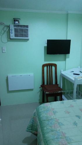 a bedroom with a bed and a chair and a desk at Dweller's Pensione in Iloilo City