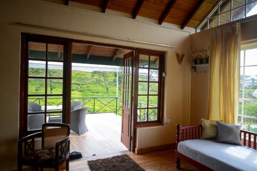 Schlafzimmer mit einem Bett und einer Glasschiebetür in der Unterkunft The Tea Garden in Nuwara Eliya