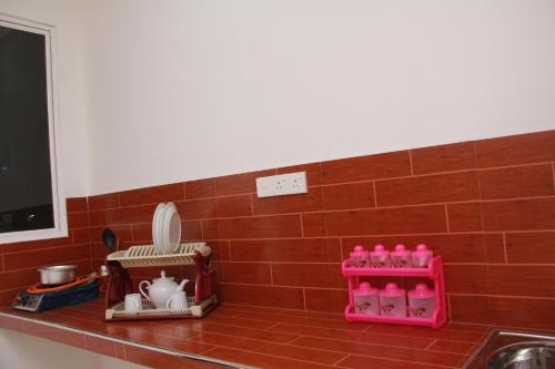 a kitchen counter with a sink and pink appliances at A One Calm Palace in Mirissa