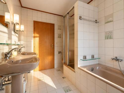 a bathroom with two sinks and a tub at Ferienwohnung Feichten in Westendorf