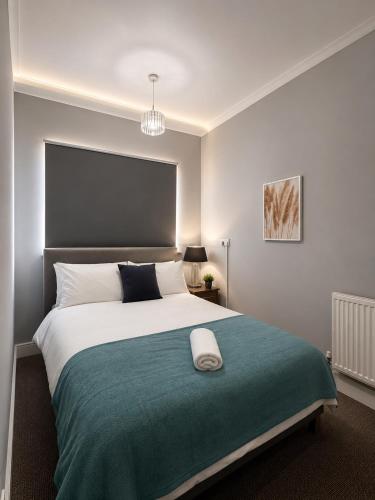 a bedroom with a large bed with a green blanket at Catherines House Kings Cross Area in London