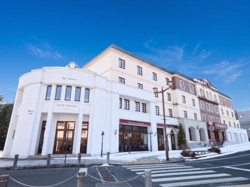 a white building on the corner of a street at Nikko Station Hotel Classic in Nikko