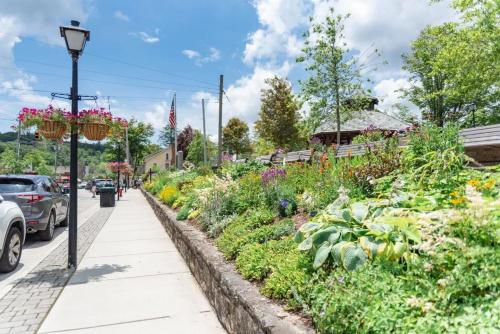 a sidewalk with a flower garden next to a street at Evergreen On Main in Blowing Rock