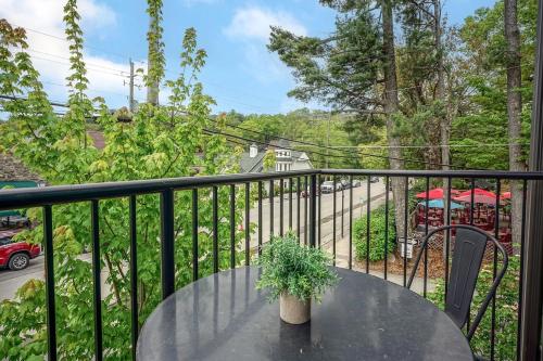 a table with a potted plant on a balcony at Evergreen On Main in Blowing Rock