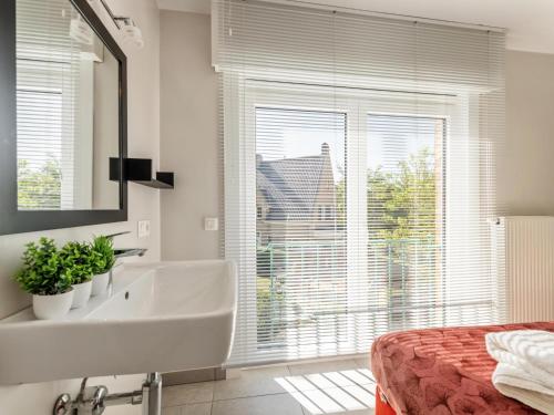 a bathroom with a sink and a large window at Elisa Beta in Nieuwpoort-Bad