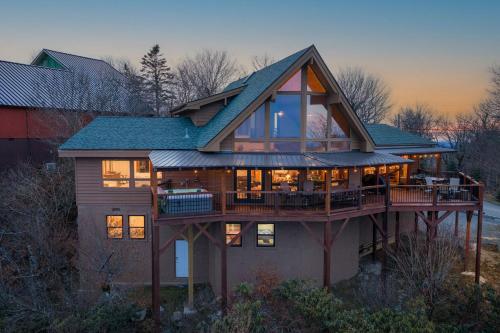a large house with a large deck with windows at Soaring Eagles View in Beech Mountain
