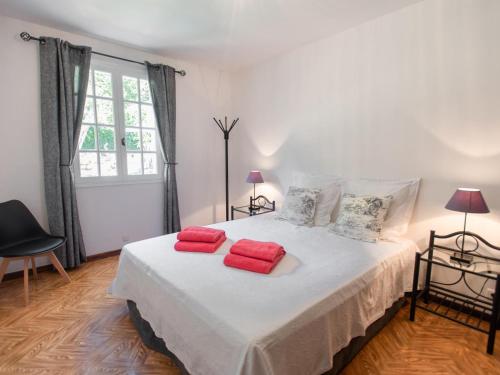 a bedroom with a bed with red towels on it at Le Rayol in Bagnols-en-Forêt