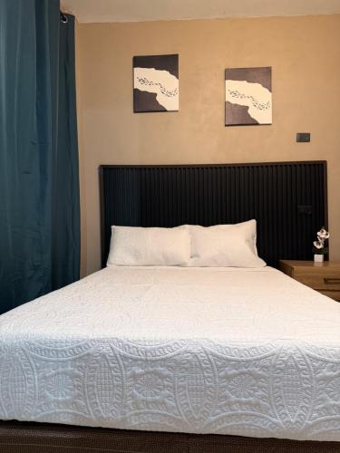 a bed in a bedroom with two pictures on the wall at Vista del Volcán in Santiago Atitlán