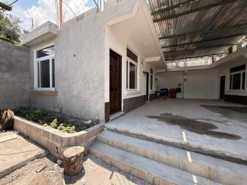 a house with a porch and stairs leading to a door at Vista del Volcán in Santiago Atitlán