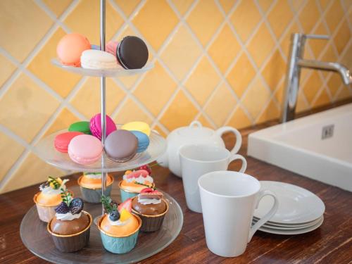 a group of cupcakes and cups on a table at Le Rayol in Bagnols-en-Forêt