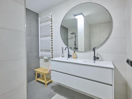 ein weißes Badezimmer mit Waschbecken und Spiegel in der Unterkunft De Douglas in Soesterberg
