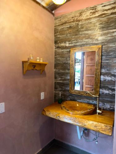 a bathroom with a wooden sink and a mirror at Chalé Pontal da Juacema in Ilha Cachoeira