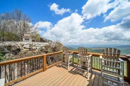 three chairs sitting on a deck with a view at On The Rocks Straight Up in Beech Mountain