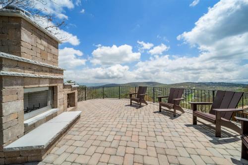 a patio with two benches and a fireplace at On The Rocks Straight Up in Beech Mountain