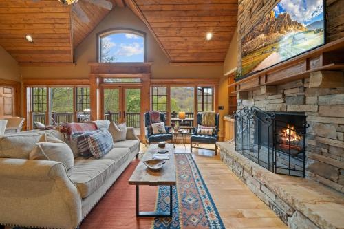 a living room with a large stone fireplace at Birds Nest On Sugar Mountain in Sugar Mountain