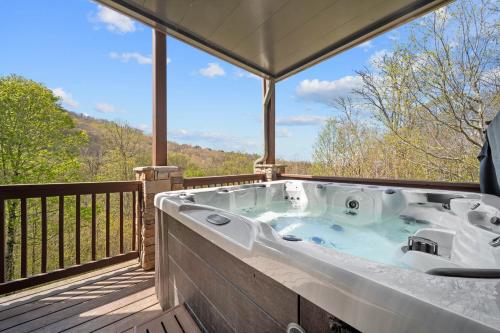 a jacuzzi tub on a deck with a view at Birds Nest On Sugar Mountain in Sugar Mountain