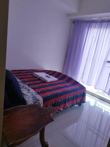 a bedroom with a bed and a window at Wind Residences in Tagaytay