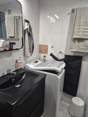 a small bathroom with a sink and a black counter at Radiowa mini in Warsaw
