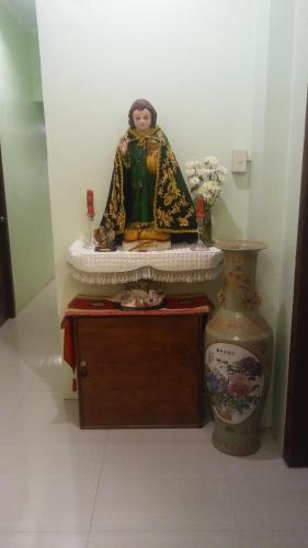 a statue of a man sitting on a table in a room at Dweller's Pensione in Iloilo City