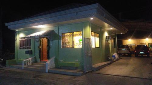 a small green building with a porch at night at Dweller's Pensione in Iloilo City
