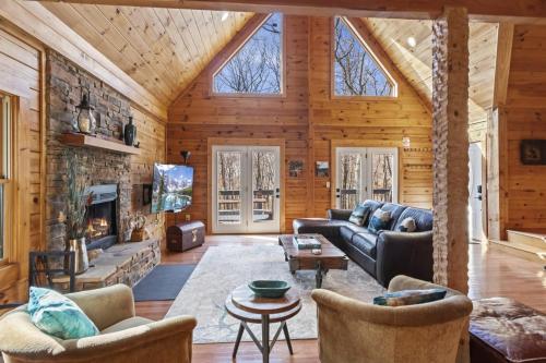 a living room with a fireplace and a stone wall at A-Typical in Boone