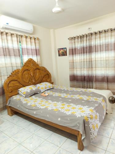 a bedroom with a wooden bed with flowers on it at Royal Palace in Dhaka