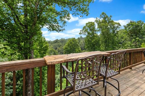 a deck with two chairs and a wooden table at Blue Mist in Blowing Rock