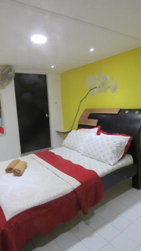 a bedroom with a bed with a red and white blanket at Posada J&J Forbes - 2 in San Andrés