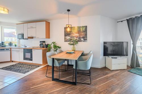 a kitchen and living room with a table and chairs at Marina Hafenblick 321 in Cuxhaven