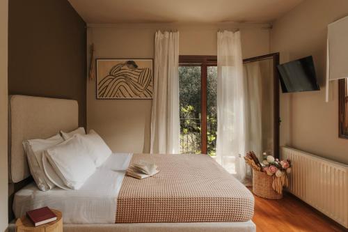 ein Schlafzimmer mit einem großen Bett und einem Fenster in der Unterkunft Endless Green, Hidden Gem in the Mountains in Artemisía