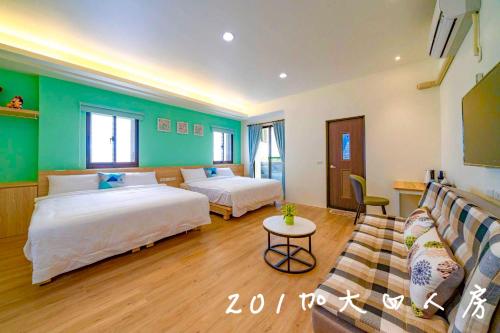 a hotel room with two beds and a couch at 晨溪民宿 in Wujie