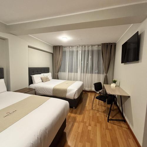 a hotel room with two beds and a television at Hotel Inkalma Santa Marta in Arequipa