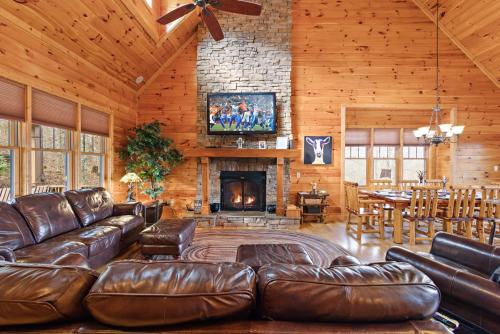 a living room with a leather couch and a fireplace at Valle Crucis Overlook in Banner Elk