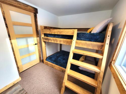 a bunk bed room with two bunk beds and a ladder at Chalet Relaxant sur Lac Forêt in Saint Zenon