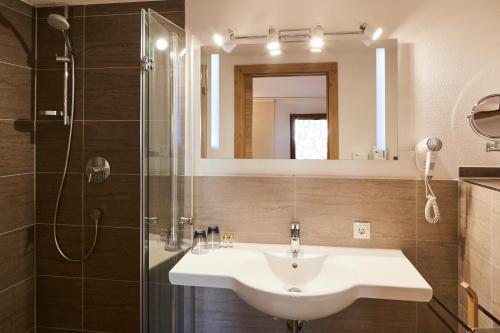 a bathroom with a sink and a shower at Tirolerhof - Appartementhaus in Kaunertal